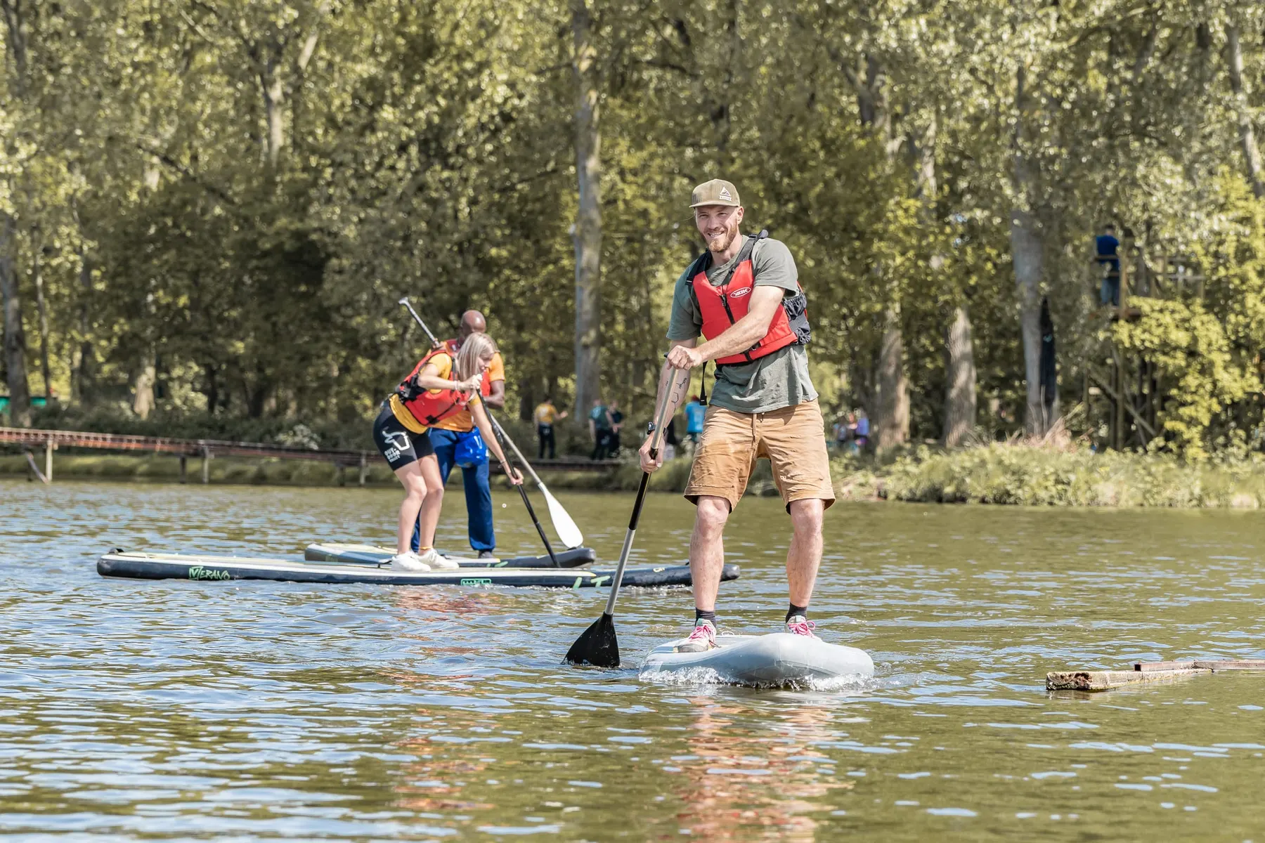 Een supper staat rechtop op zijn board en peddelt over het water