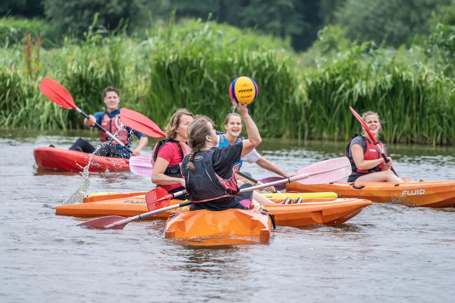 Kajakkers strijden om de bal voor het doel op het water