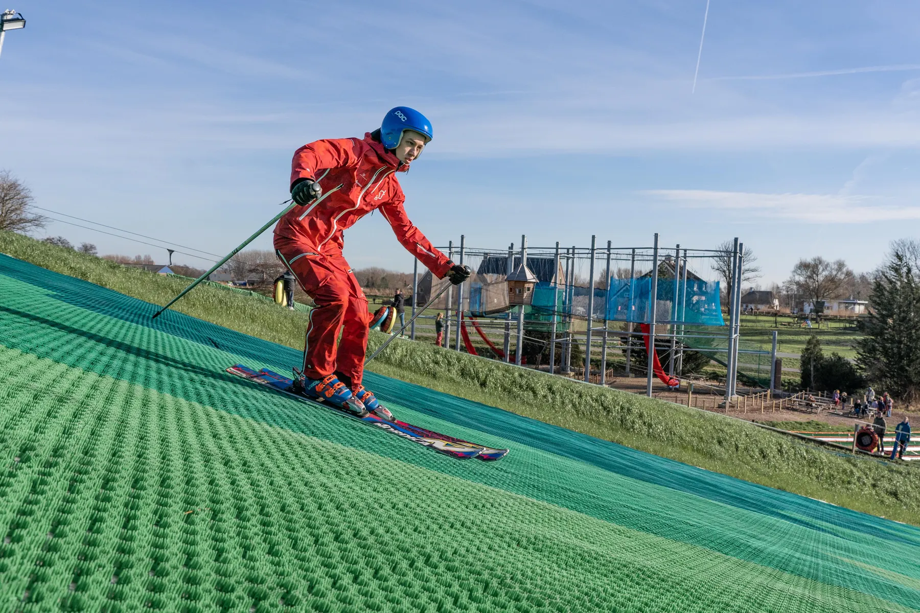 Een skiër met helm daalt af over de outdoor skibaan